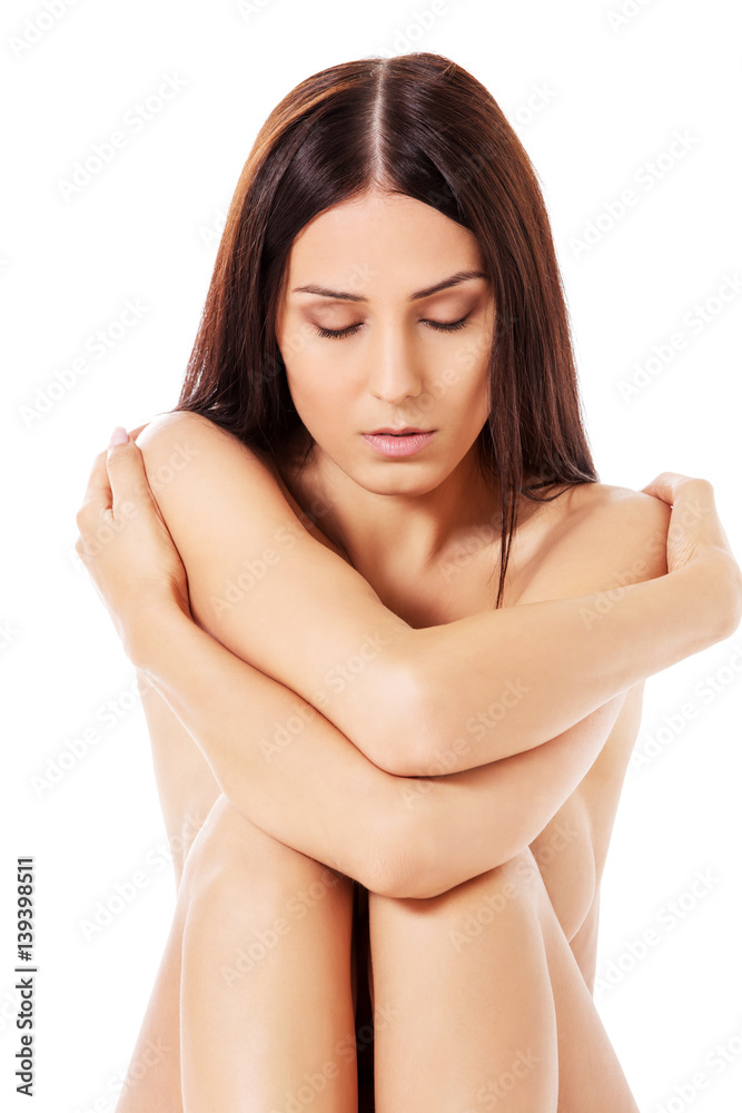 Fototapeta premium Nude worried woman sitting on the floor