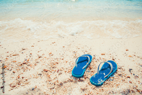 Summer vacation concept - slippers on tropical beach. Leisure in summer - vintage color tone effect
