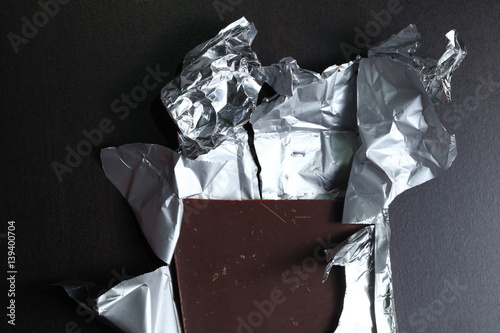 The dark chocolate bar put on dark color wood background represent the food and confectionery concept related idea.