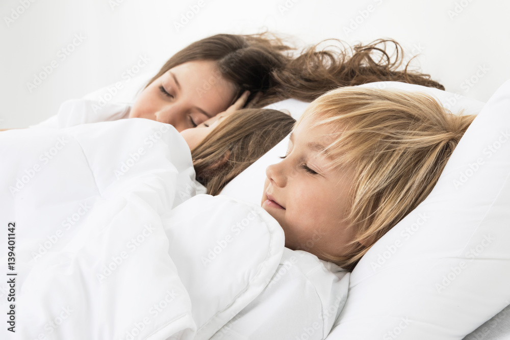 Three children sleeping in bed Three children sleeping in bed