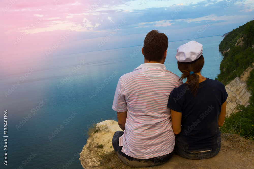 boy and girl sit on the rock