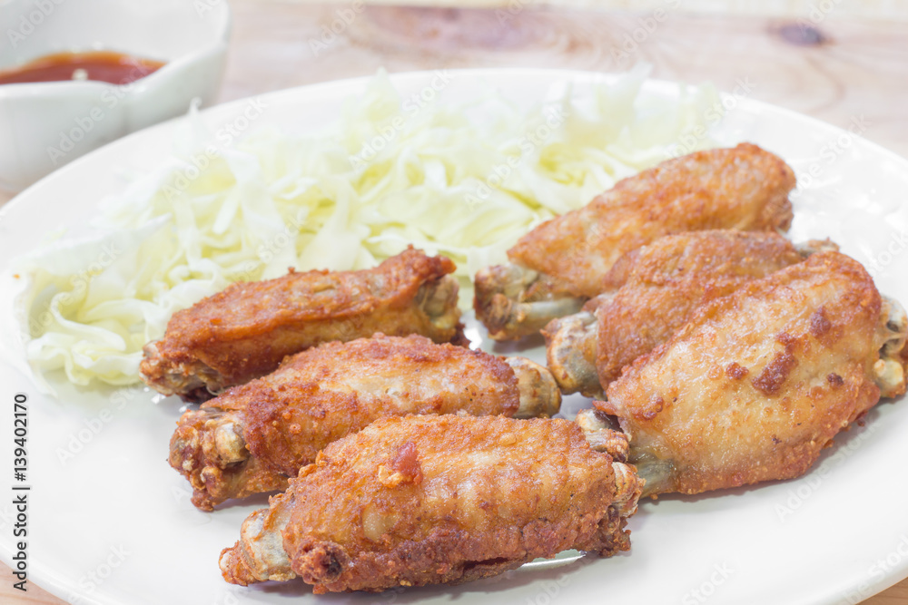 Chicken wings in plate with and cabbage alley.