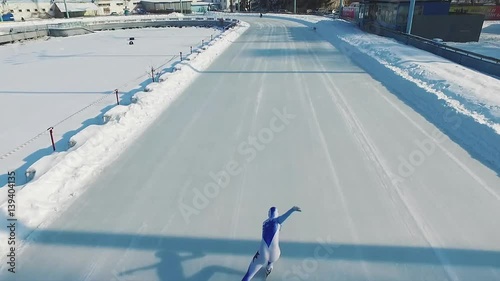 Speed ice skater skating on outdoor race HD aerial video. Flying over professional athlete training for winter olympic