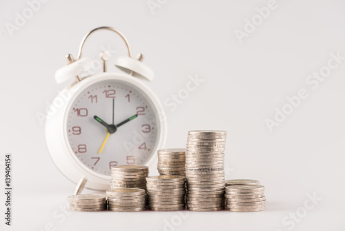 Close up of stacking gold coins with alarm clock ,Business Finance and Money concept,Save money for prepare in the future.