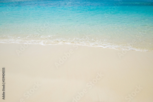 Blue sea wave on sand beach. Summer holiday relax background with copy space.