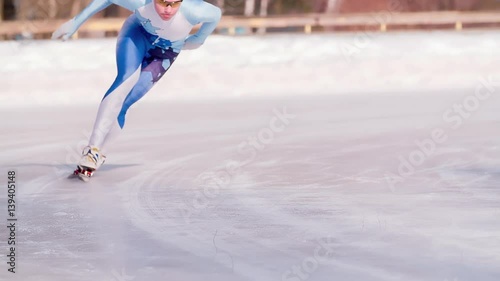 Speed ice skater skating on outdoor race on turn HD slow-motion video. Professional athlete training for winter olympic. View of legs on skates