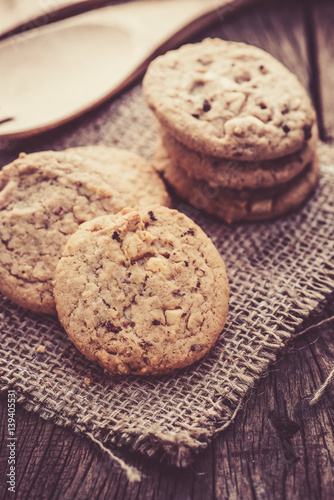 Chocolate cookies on white linen napkin on wooden table. Chocolate chip cookies shot on sack