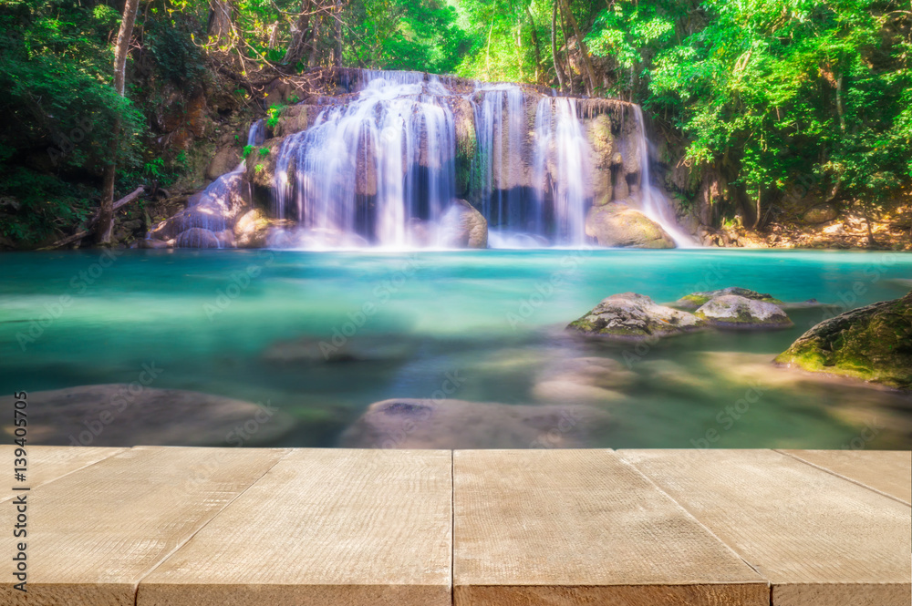 Wood floor scene of beautiful waterfall in fresh deep green forest. Holiday vacation travel relax background with copy space for decorate design.