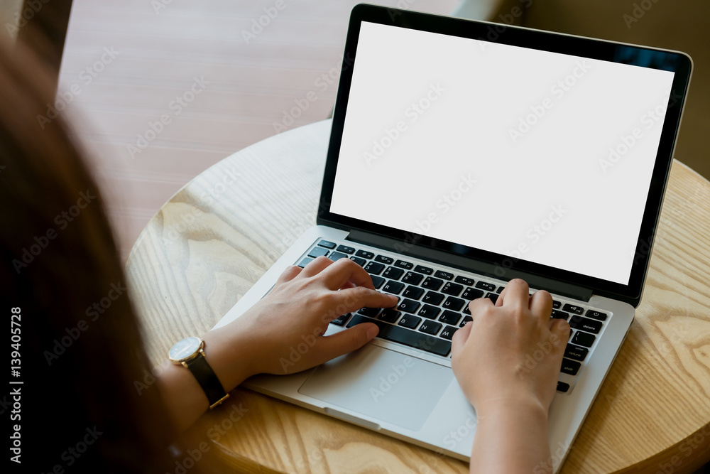 Mockup image of hands using laptop with blank white screen on vintage wooden table in cafe Mockup image of hands using laptop with blank white screen on vintage wooden table in cafe