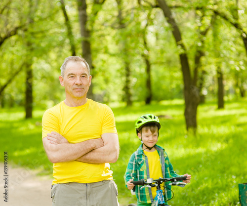 Senior man and child on a bicycle in the park