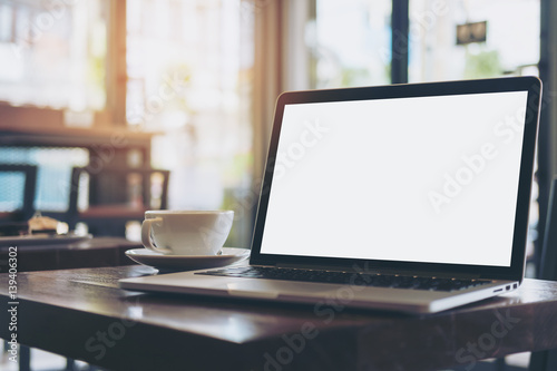 Mockup image of laptop with blank white screen on wooden table in modern loft cafe © Farknot Architect