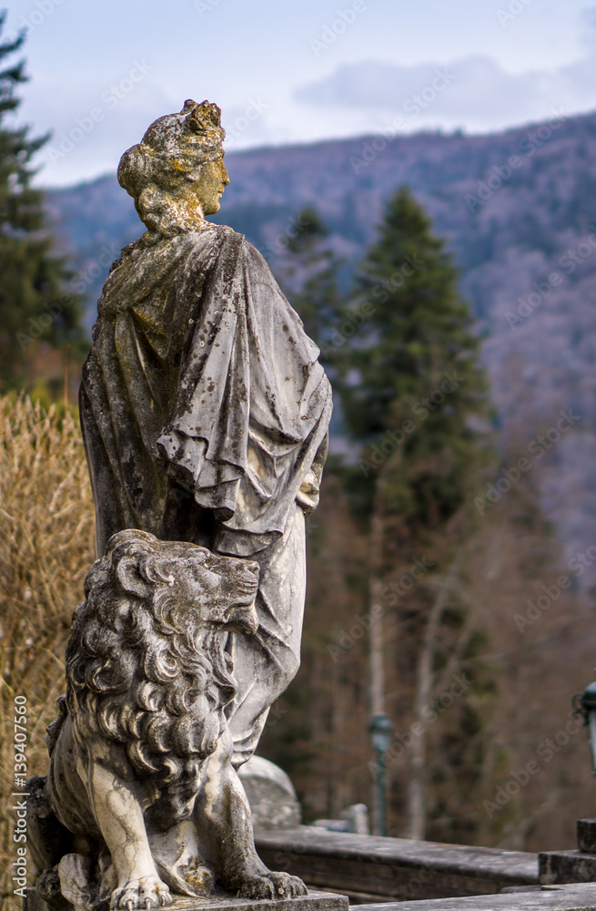 Obraz premium The lady and her lion made from stone, statues in a public park