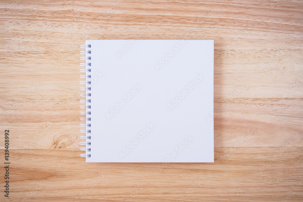white cover notebook on brown wood desk background white cover notebook on brown wood desk background