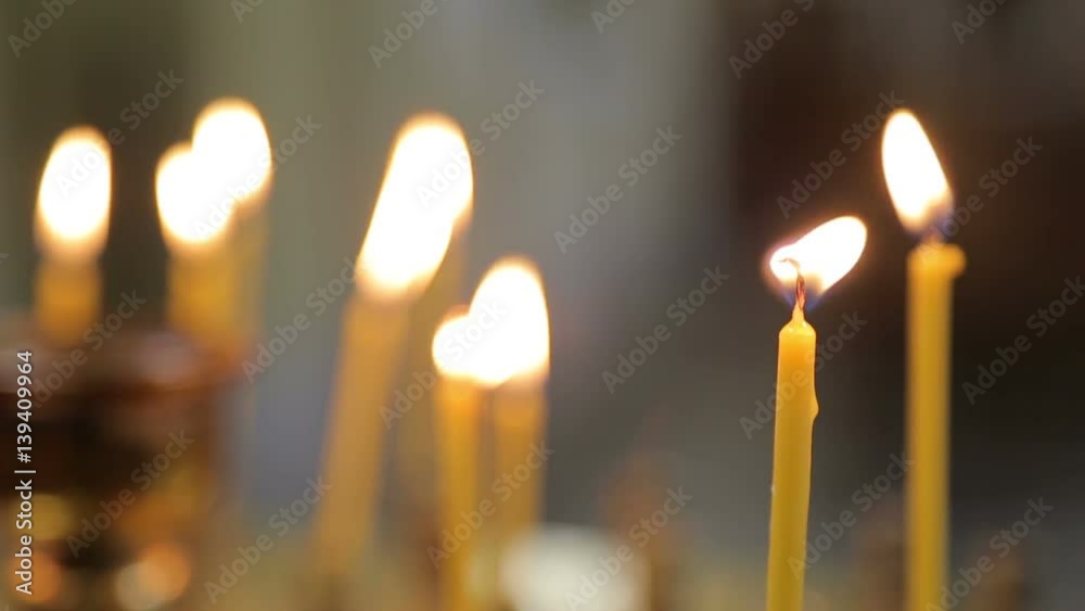 many yellow candles burning in church? Close up. many yellow candles burning in church? Close up.