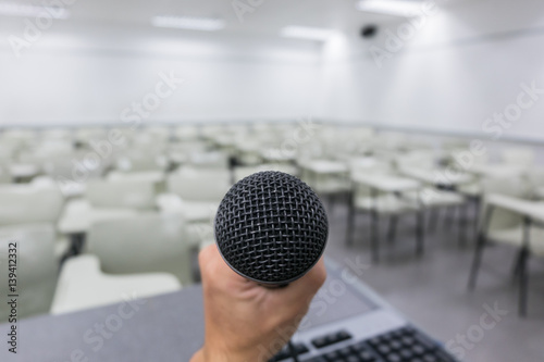 Holding microphone in hand in classroom