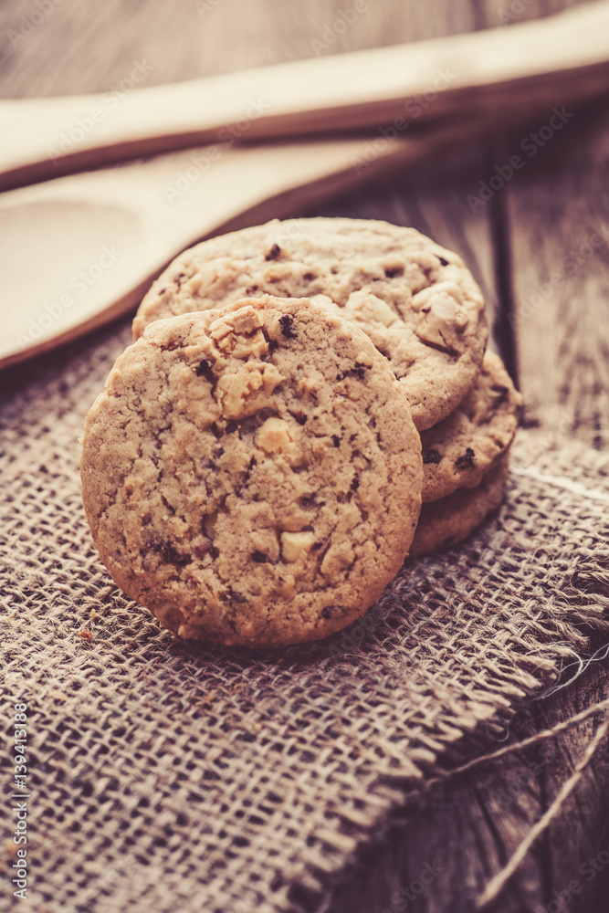 Chocolate cookies on white linen napkin on wooden table. Chocolate chip cookies shot on sack Chocolate cookies on white linen napkin on wooden table. Chocolate chip cookies shot on sack