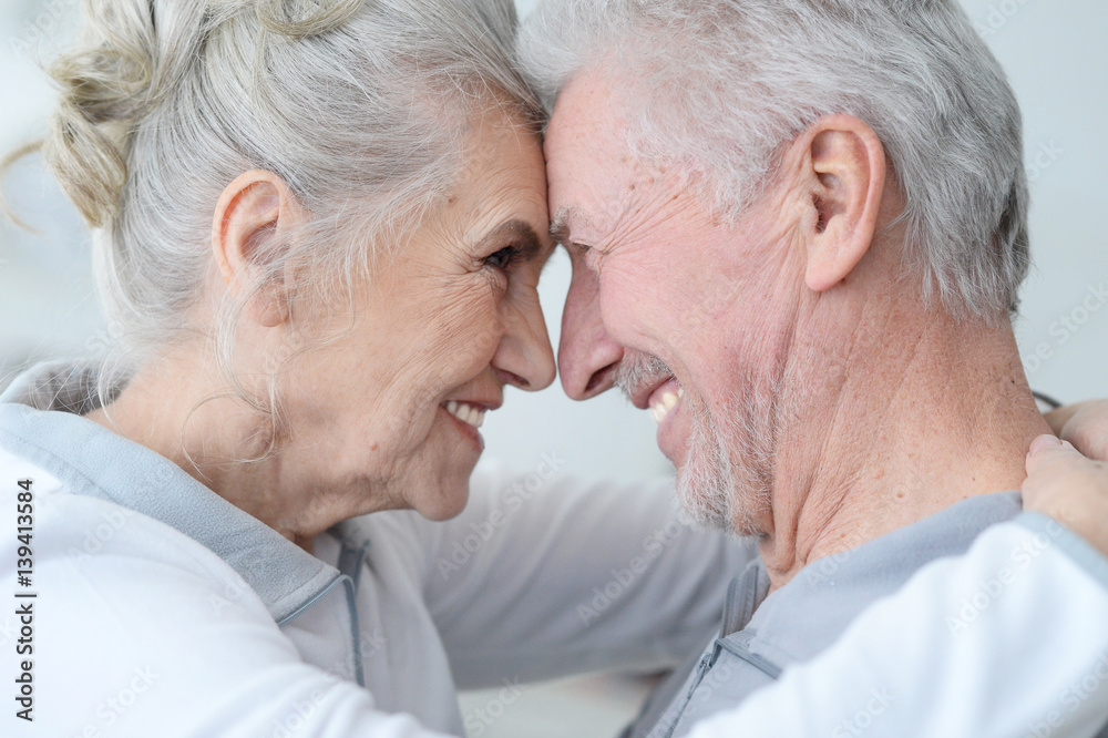 Happy elderly couple standing embracing Happy elderly couple standing embracing