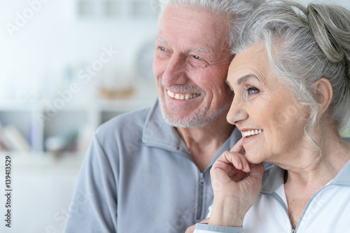 Happy elderly couple standing embracing