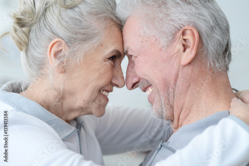 Happy elderly couple standing embracing