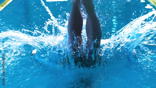 Male swimmer diving into pool HD slow-motion video. Professional athlete training: splashes water surface