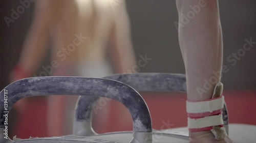Gymnast doing routine exercises on pommel horse HD video. Close-up of athlete hand on gymnastics apparatus.