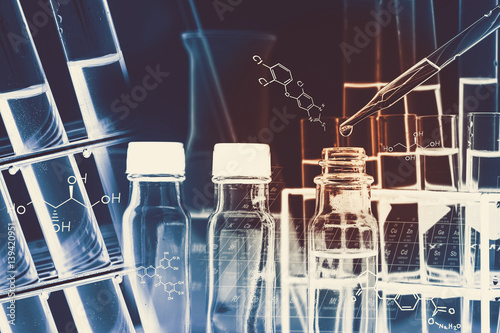 Researcher is dropping the reagent into test tube, with chemical equations background, in laboratory