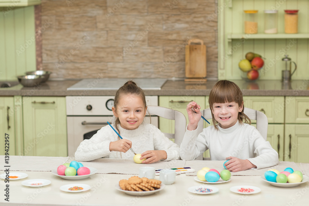 Fototapeta premium Brother and sister painted Easter eggs at the table