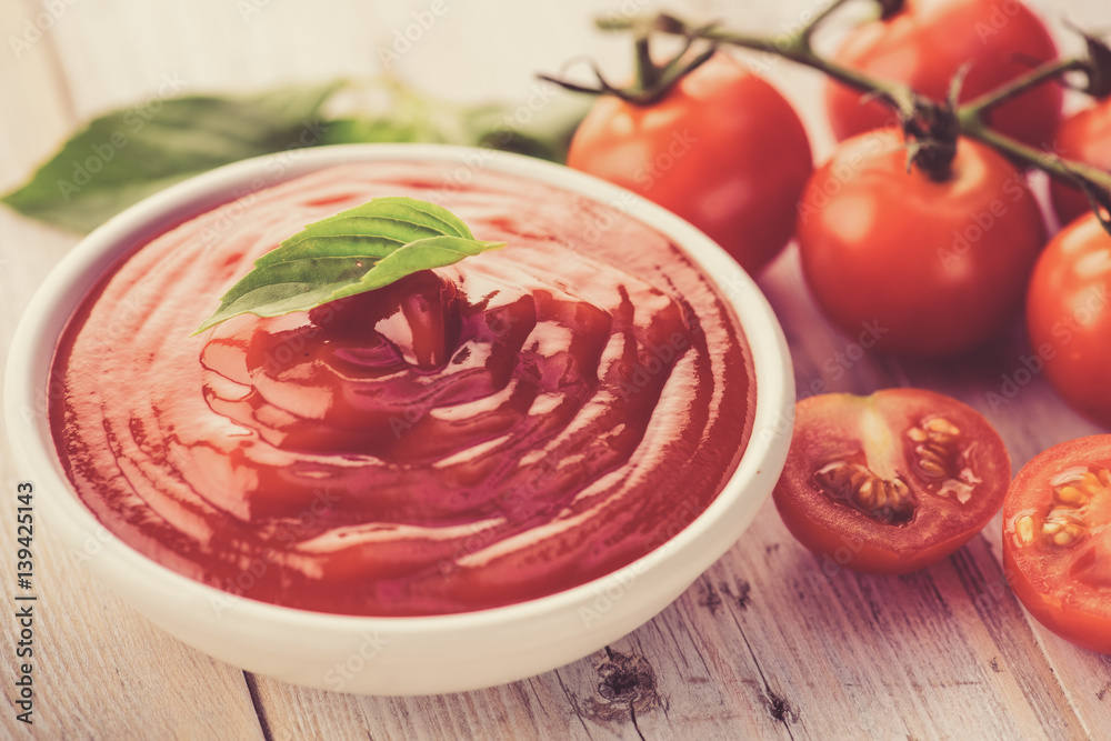 bowl of ketchup or tomato sauce and fresh tomatoes on wood table bowl of ketchup or tomato sauce and fresh tomatoes on wood table