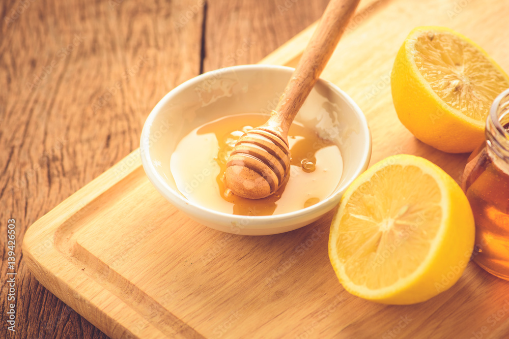 Lemon slice with honey on wood table Lemon slice with honey on wood table