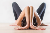 Woman doing yoga lying on floor in artistic aesthetical posture.