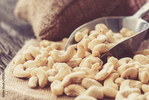 raw cashew nuts with stainless spoon on wood table