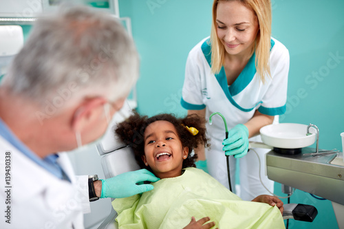 Little black patient show teeth to her dentist