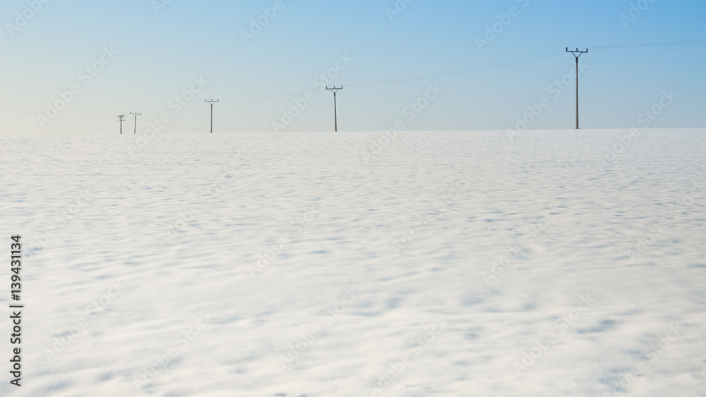 Electric poles in the field, winter season