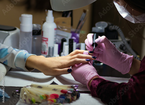 Girl does a manicure in a beauty salon
