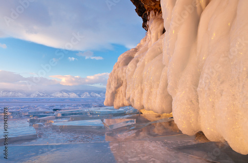 Lake Baikal in winter. Icy cliffs at sunset reflected in the transparent ice floes