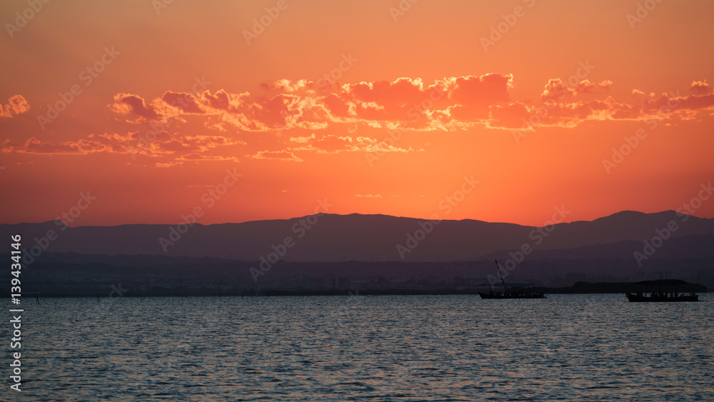 Sunset at albufera wetlands with tourist boats