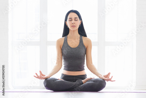 Young woman in white doing yoga pose