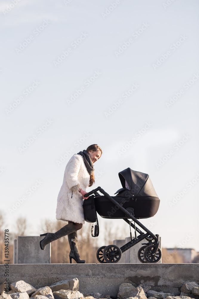 Obraz premium young mother walking with baby, good weather for walking, healthy lifestyle