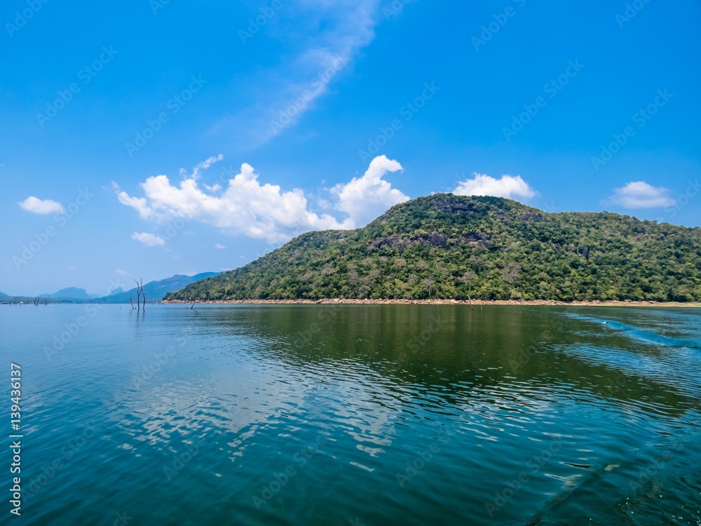 Reflection on a Lake of Beautiful Island Trees greenery land with bluesky and clouds in Sri Lanka