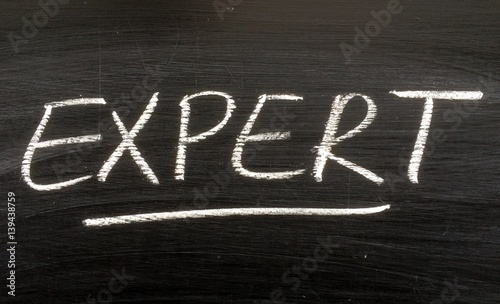 The word EXPERT written by hand in white chalk on a blackboard