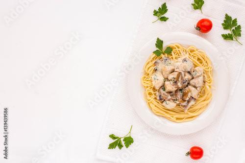 Spaghetti pasta with champignons, chiken and sauce on white background. Flat lay.