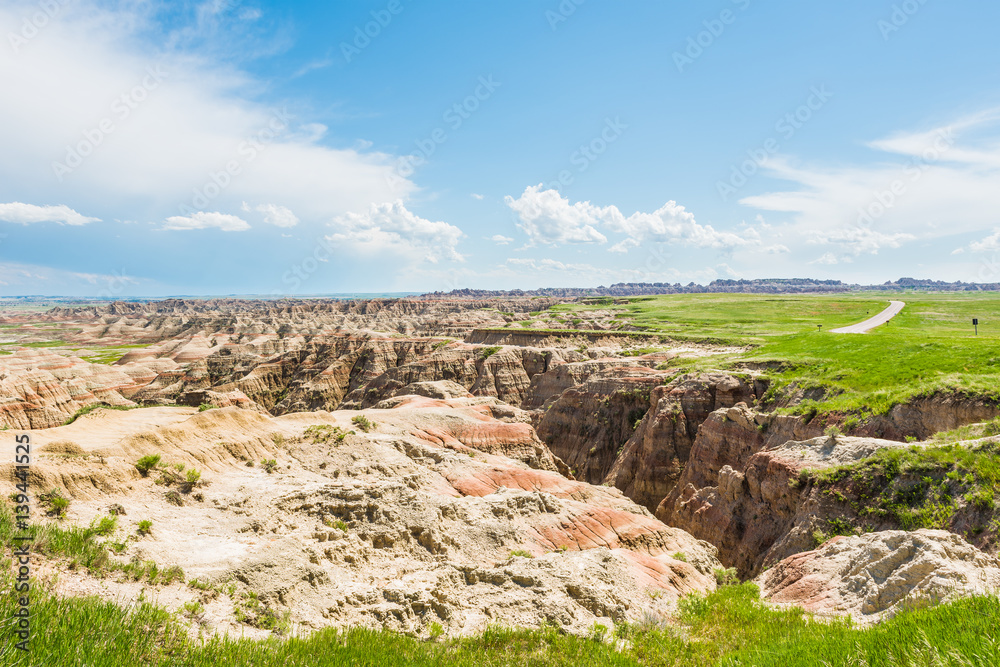Badlands canyons with green grass and road