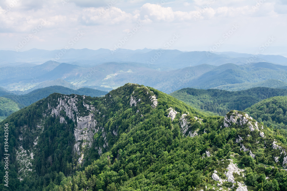 Panoramic view from the top of mountain to many mountain peaks around in Risnjak National Park in Croatia. Magnificent mountain ridge on foreground.