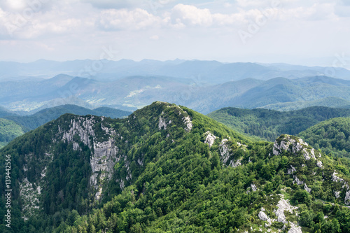 Fototapeta Naklejka Na Ścianę i Meble -  Panoramic view from the top of mountain to many mountain peaks around in Risnjak National Park in Croatia. Magnificent mountain ridge on foreground.