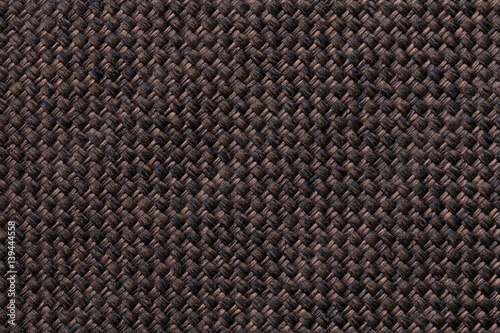 Dark brown textile background closeup. Structure of the fabric macro