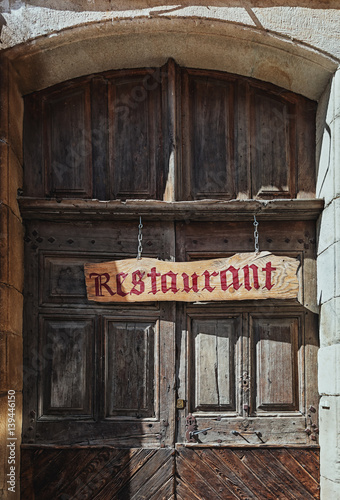 Image of an old restaurant door in a street in the center of Largentiere