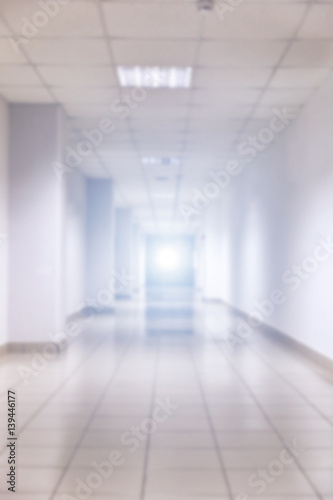 Abstract blur white empty interior room or blurred corridor with light at the end wall
