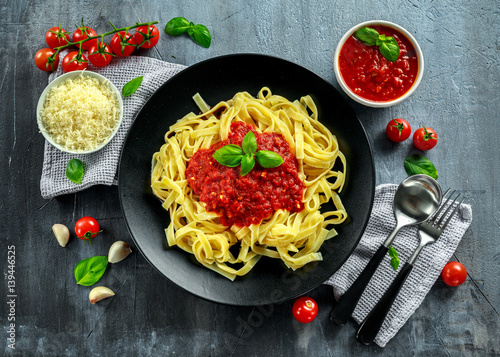 Homemade Hot Pasta with Marinara Sauce, Basil, Garlic, Tomatoes, parmesan cheese on plate. photo