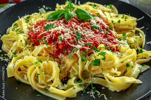 Homemade Hot Pasta with Marinara Sauce, Basil, Garlic, Tomatoes, parmesan cheese on plate.