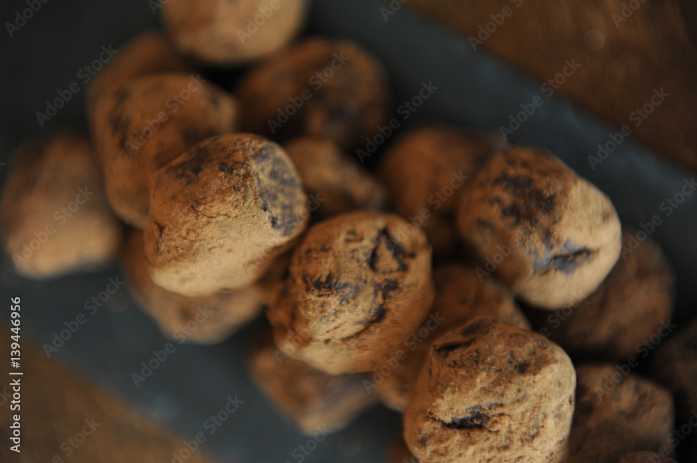 Chocolate truffles in cocoa sprinkled. On the slate board on wooden background. Close-up, texture Chocolate truffles in cocoa sprinkled. On the slate board on wooden background. Close-up, texture